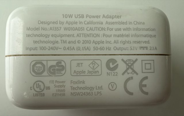 10W USB Power Adapter. Designed by Apple in California, Assembled in China. Model No. A1357. W010A051. Input 100-240V~ 0.45A 50-60Hz. Output 5.1V at 2.1A. TM and copyright 2010 Apple Inc. Foxlink Technology Ltd. E211458. LPS.