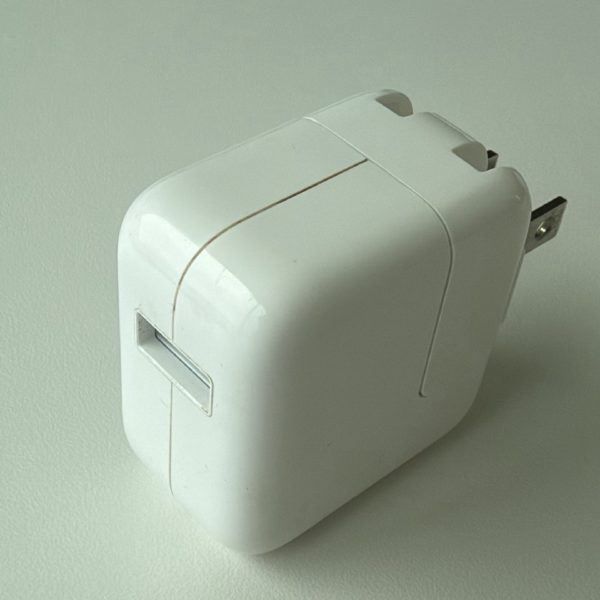 Apple 12W USB Power Adapter, model A1401, with a single USB-A port and a folding prong.
