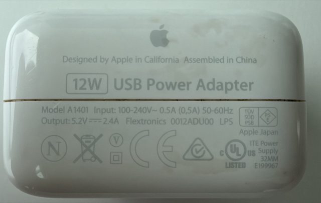 12W USB Power Adapter. Designed by Apple in California, Assembled in China. Model A1401. Input 100-240V~ 0.5A 50-60Hz. Output 5.2V at 2.4A. Flextronics. LPS.