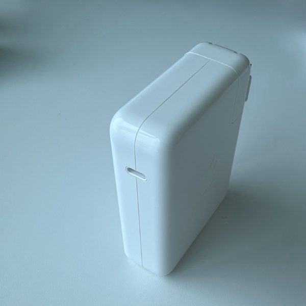 Apple 140W USB-C Power Adapter, model A2452, with its folding prongs extended.