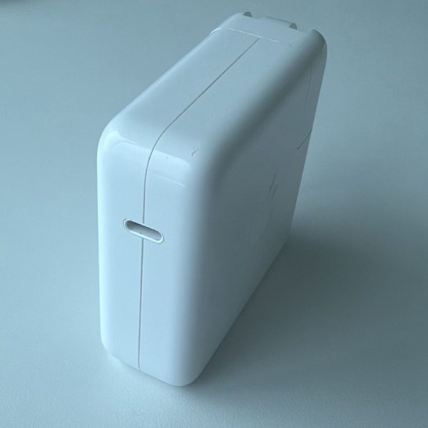 Apple 67W USB-C Power Adapter, model A2518, with folding prongs.