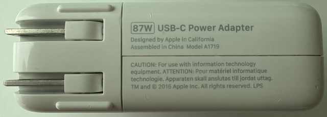 87W USB-C Power Adapter. Designed by Apple in California, Assembled in China. Model A1719. TM and copyright 2016 Apple Inc. LPS.
